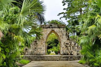 Arche de pierre entourée de palmiers et de végétation tropicale au Mexique